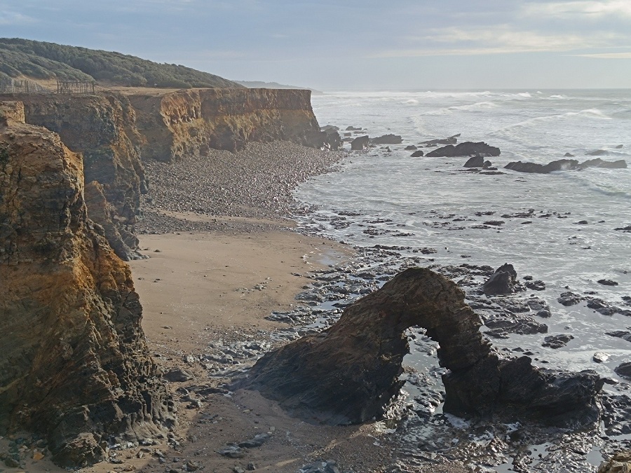 Photographie de falaises surplombant une plage et la mer.